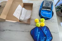 The Panel Sound Pickleball Paddles Set of 2 and its parts on a marble counter
