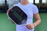 A person holding the Selkirk SLK Evo Power 2.0 Pickleball Paddle