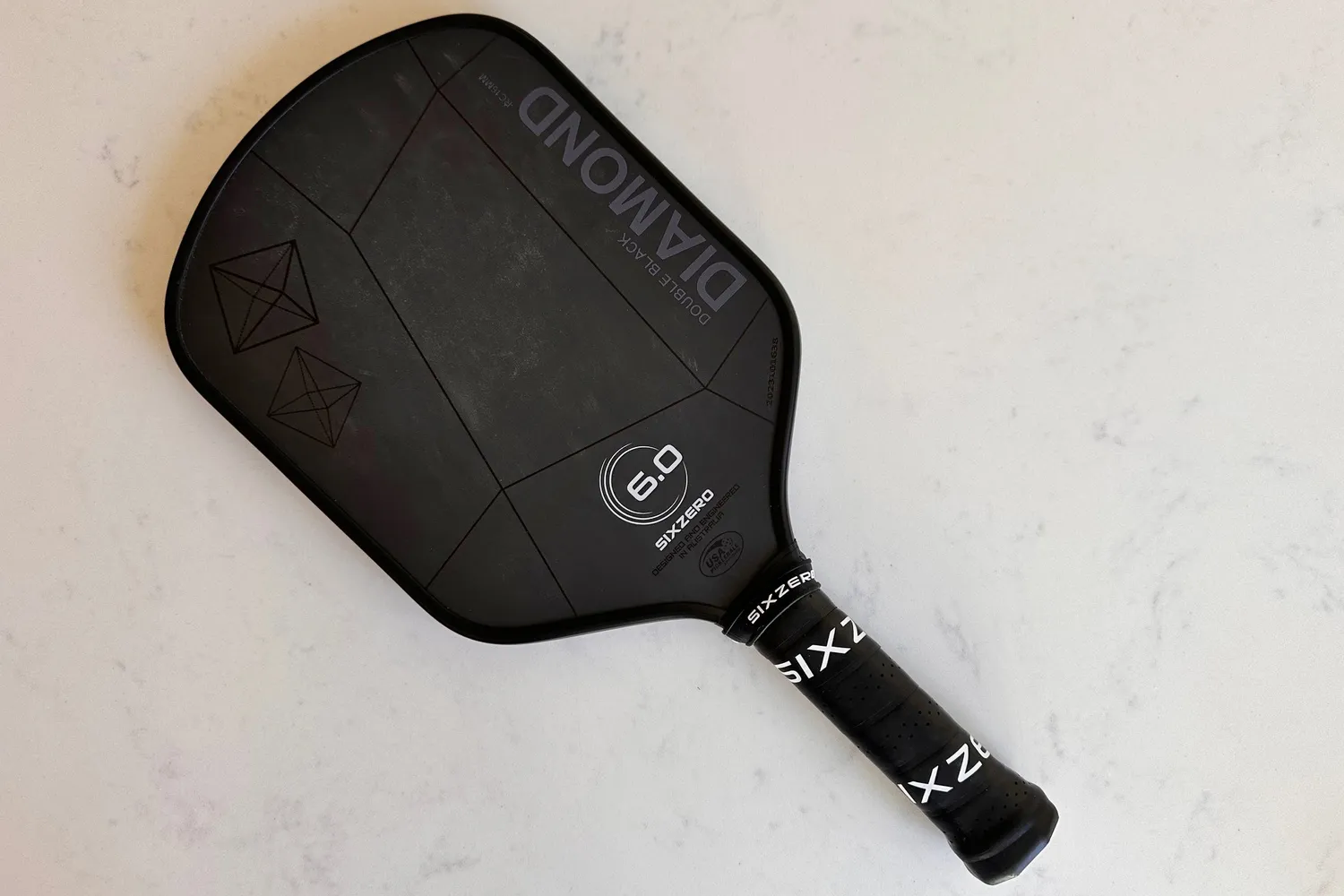 The Six Zero 16mm Double Black Diamond Control Pickleball Paddle on a white countertop