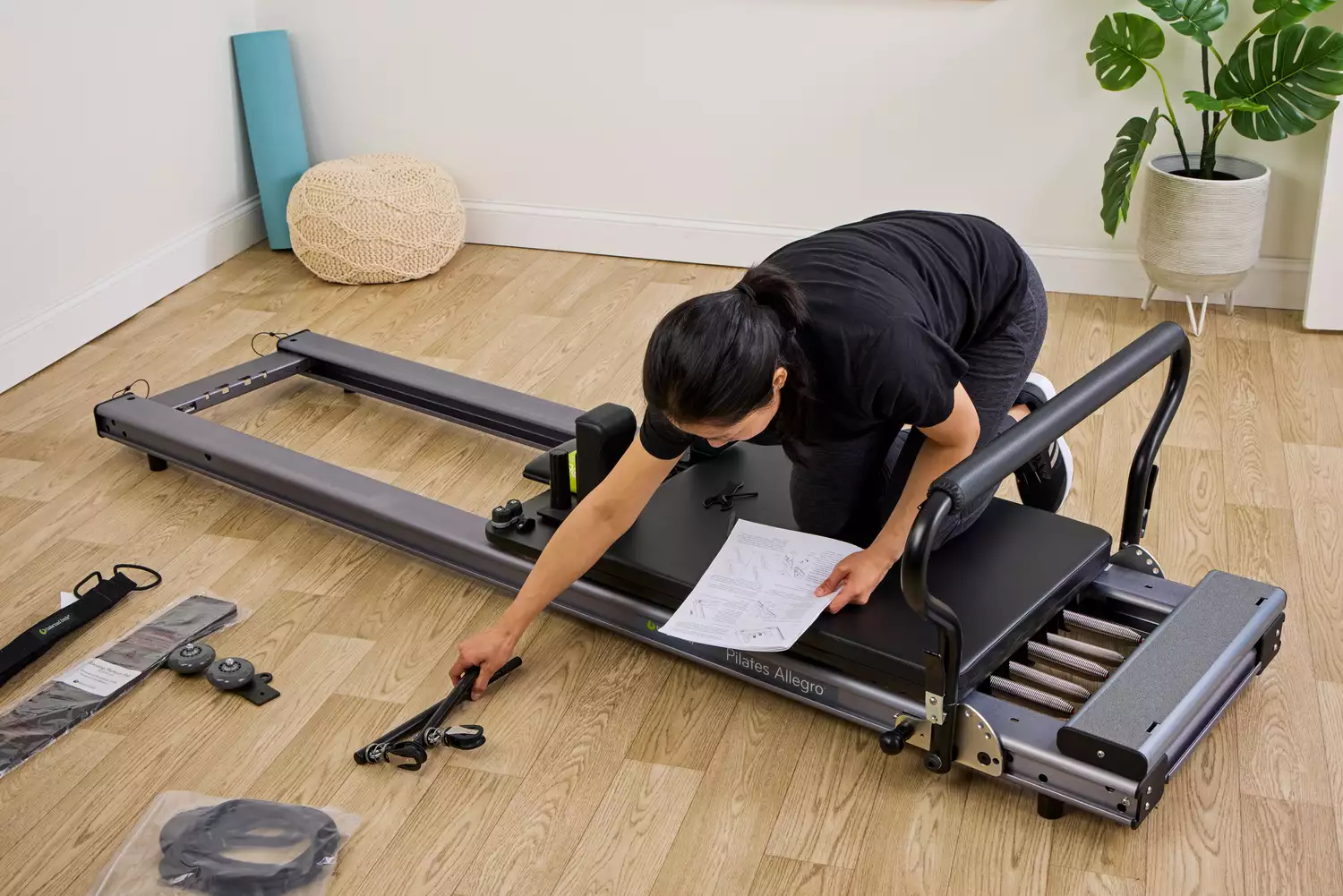 A person assembles the Balanced Body Allegro Reformer