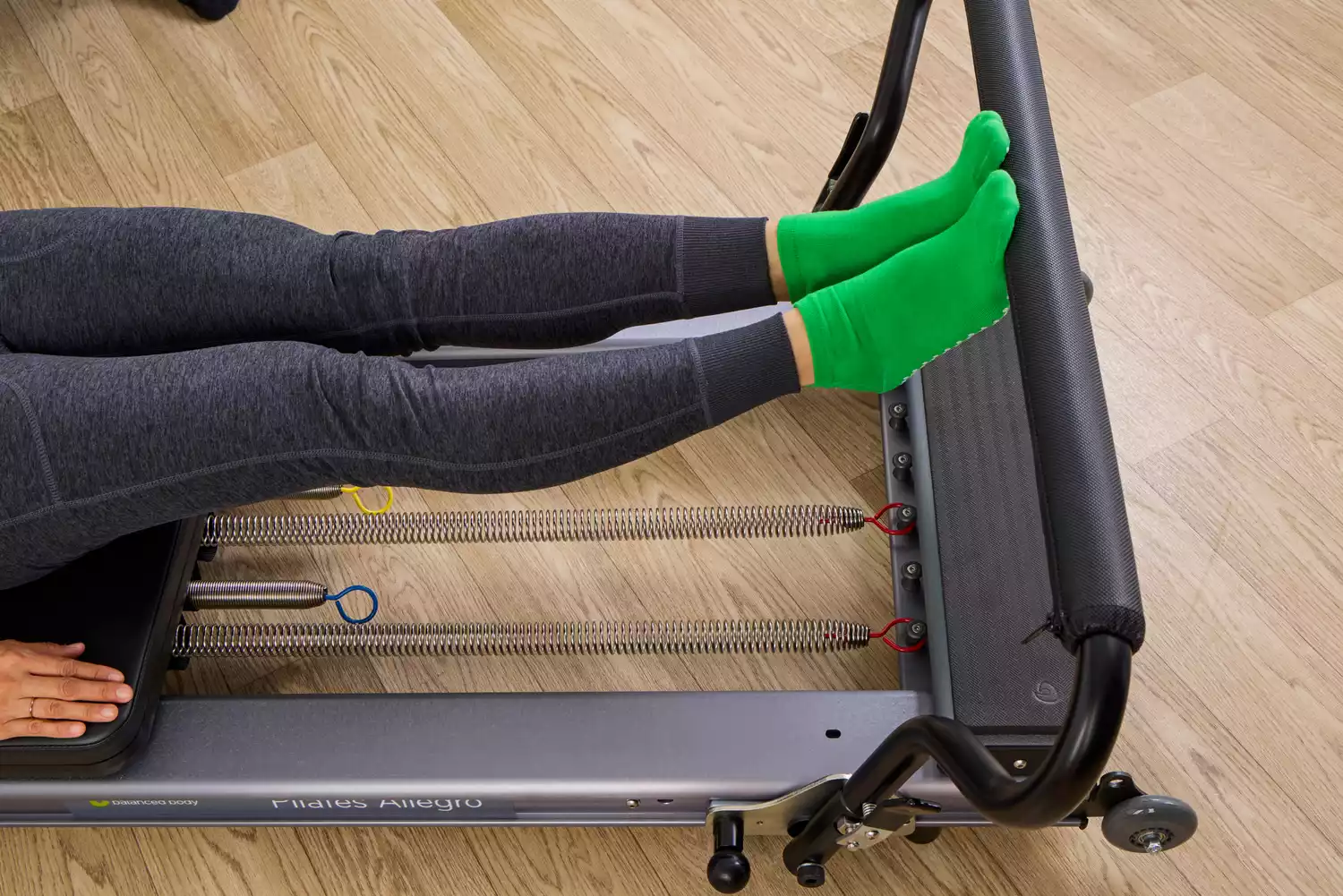 A person exercises using the Balanced Body Allegro Reformer