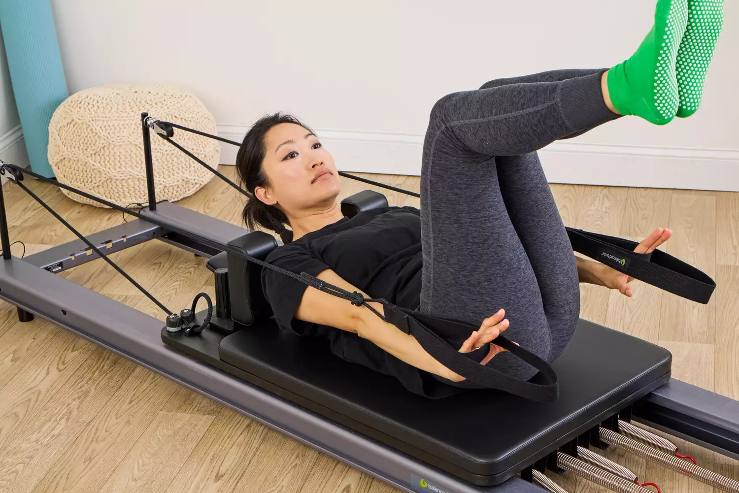 A person exercises using the Balanced Body Allegro Reformer