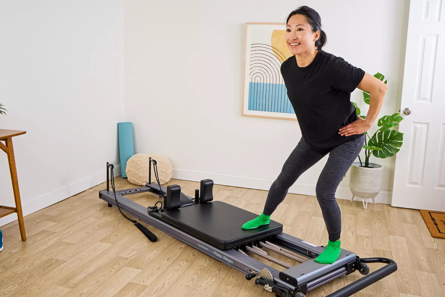 A person exercises using the Balanced Body Allegro Reformer