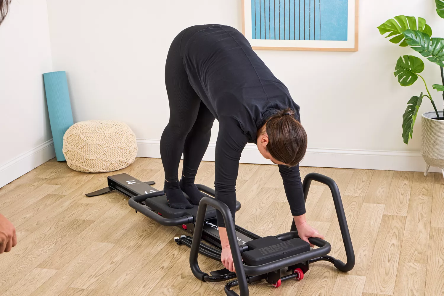 A person exercises using the Lagree Micro Reformer