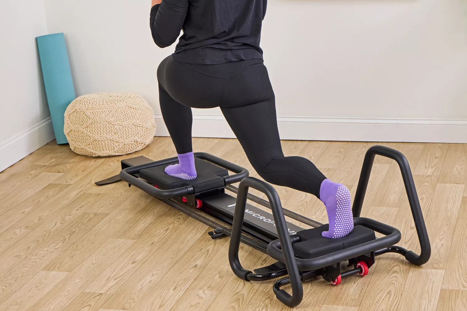 A person exercises using the Lagree Micro Reformer
