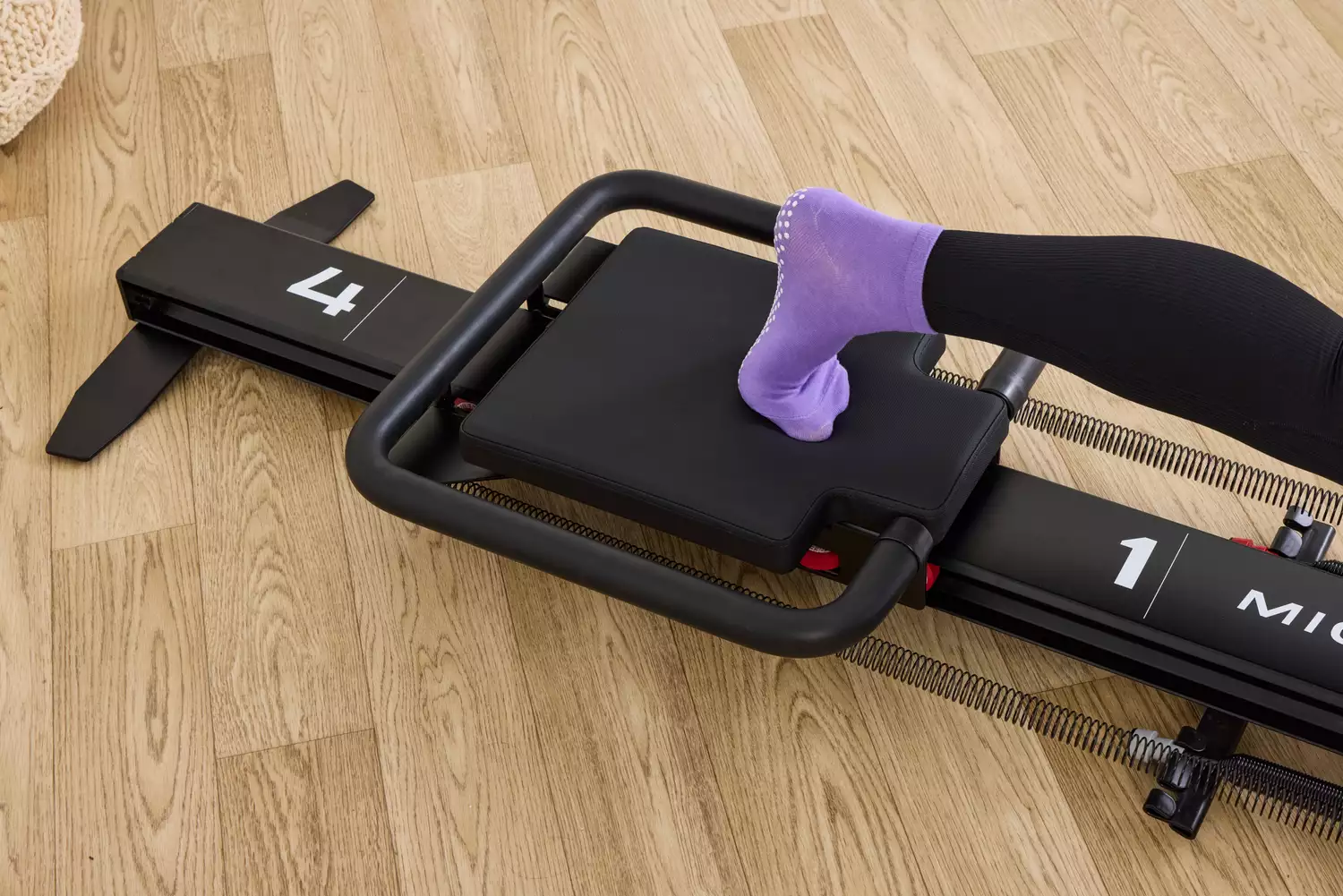 A closeup of a person's foot on the Lagree Micro Reformer
