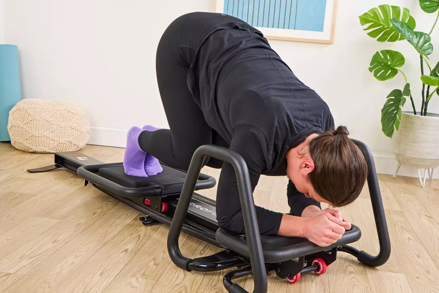 A person exercises using the Lagree Micro Reformer