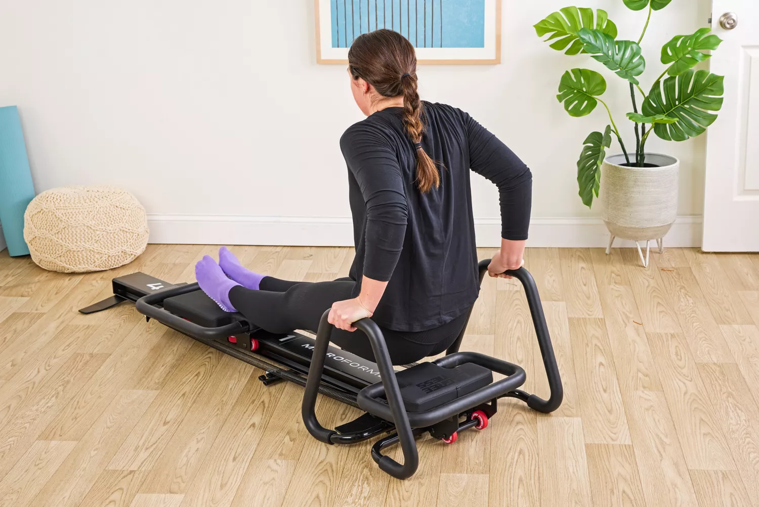 A person exercises using the Lagree Micro Reformer