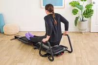 A person exercises using the Lagree Micro Reformer