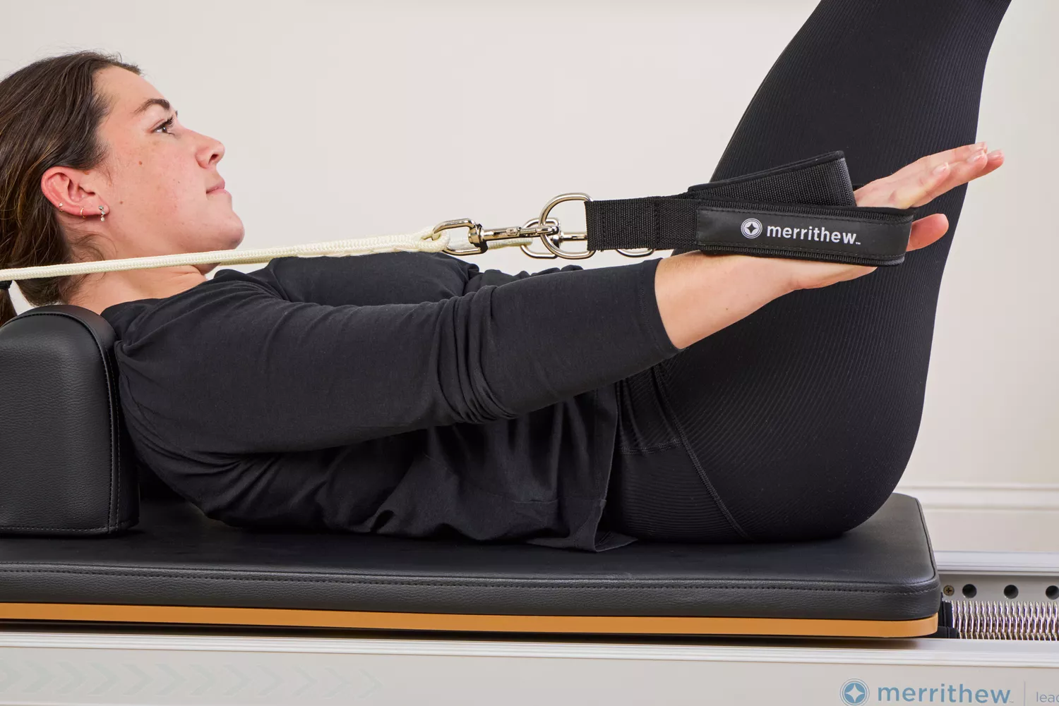 A person exercises using the Merrithew At Home SPX Reformer Bundle