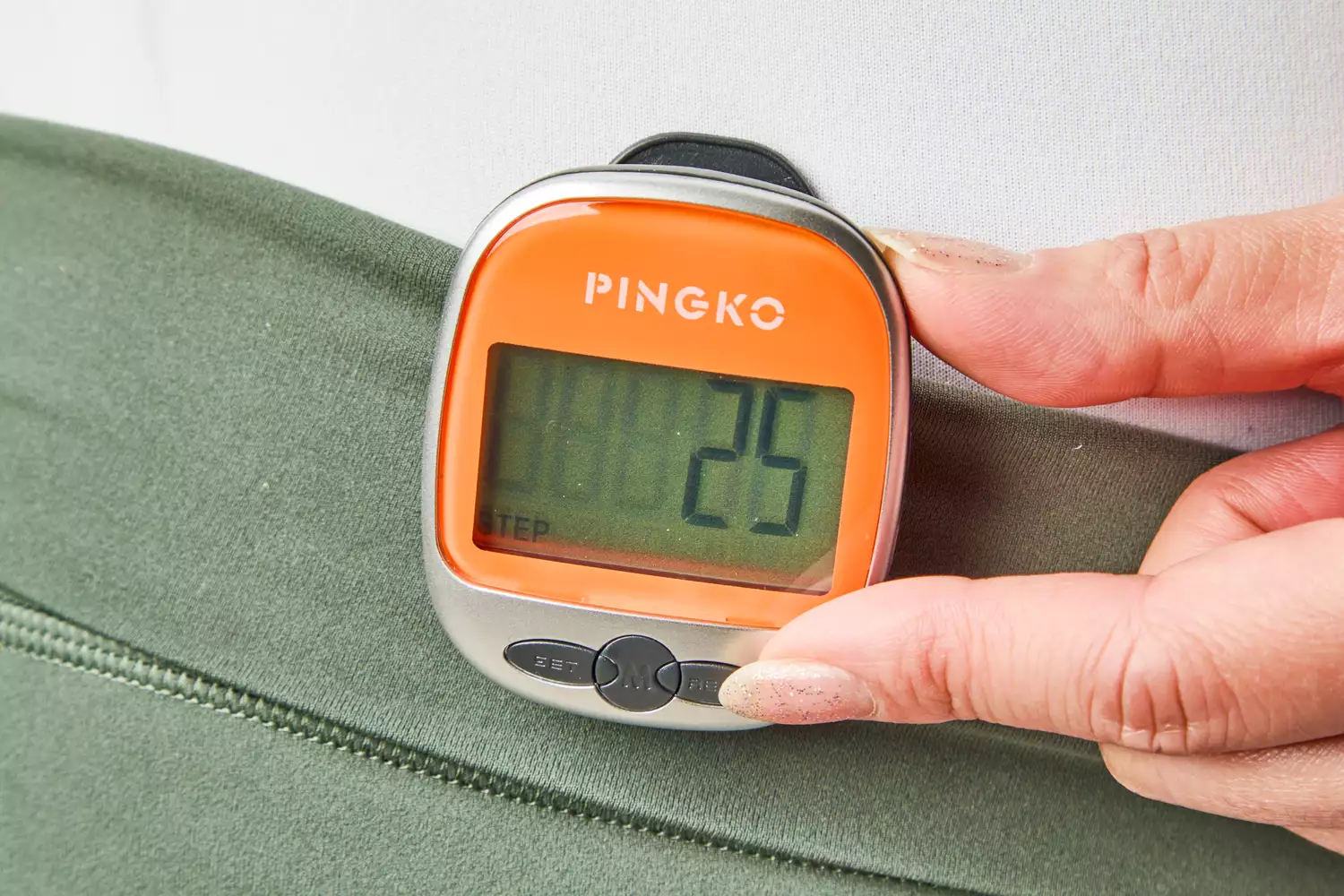 A person presses a button on the PINGKO Outdoor Multi-Function Portable Sport Pedometer