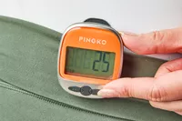 A person presses a button on the PINGKO Outdoor Multi-Function Portable Sport Pedometer