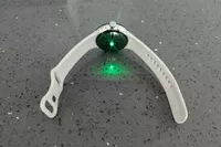 The Google Pixel Watch 3 with a green glowing light on the back of it