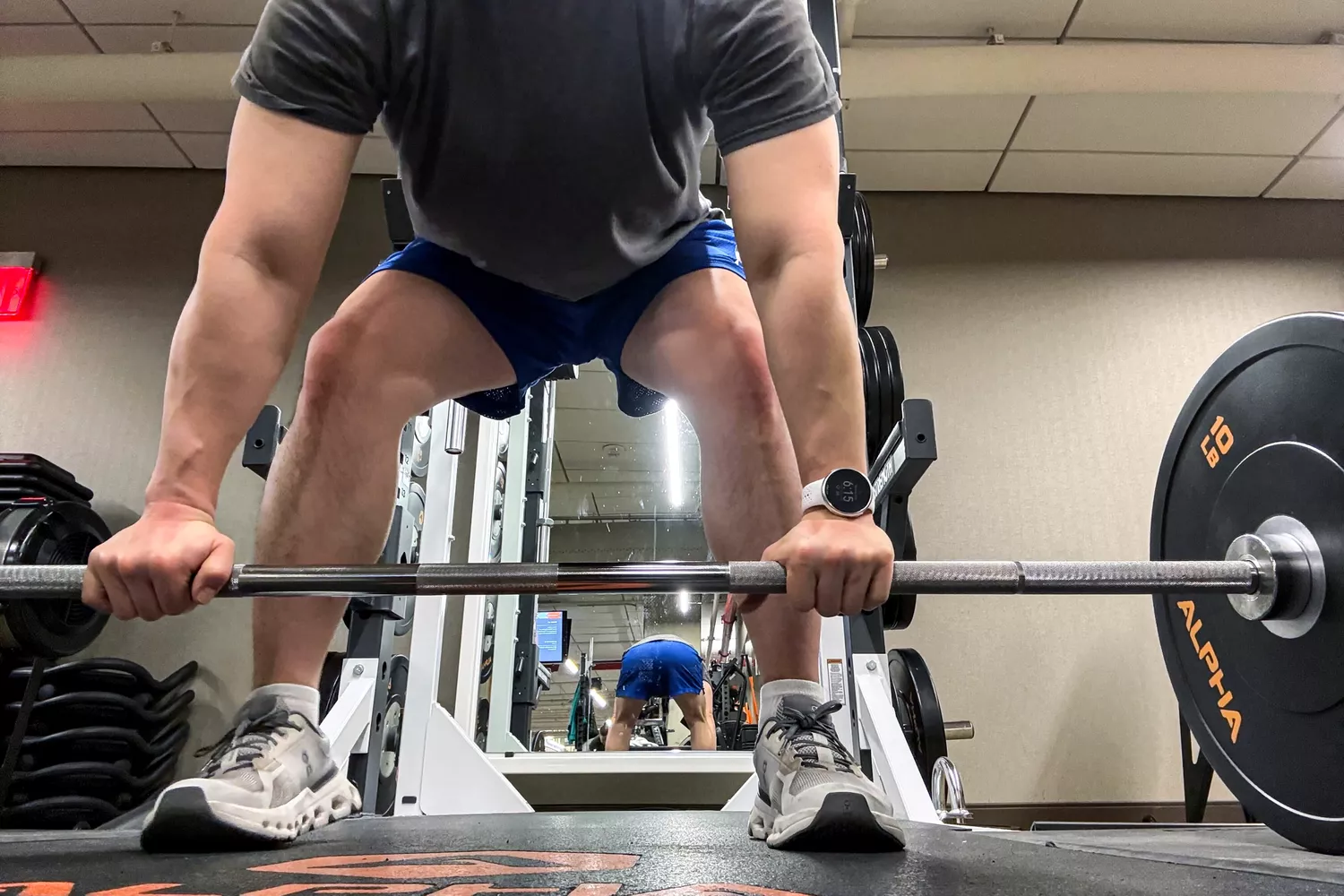 A person lifts a weight while wearing the Polar Pacer Pro Advanced GPS Sports Watch