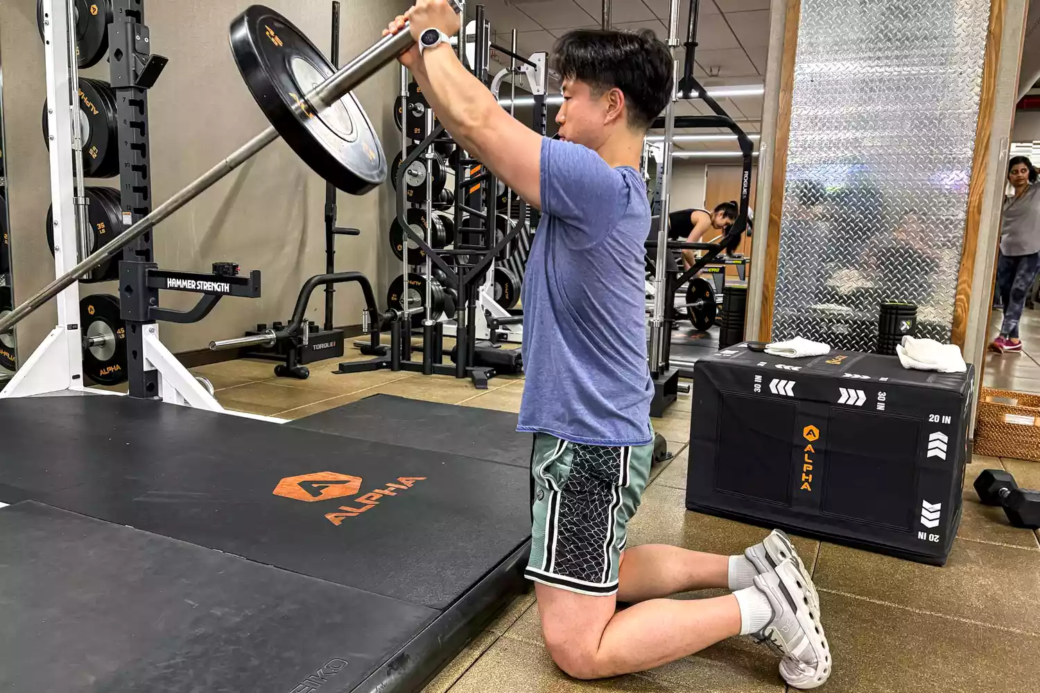 A person lifts weights while wearing the Polar Pacer Pro Advanced GPS Sports Watch