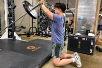 A person lifts weights while wearing the Polar Pacer Pro Advanced GPS Sports Watch