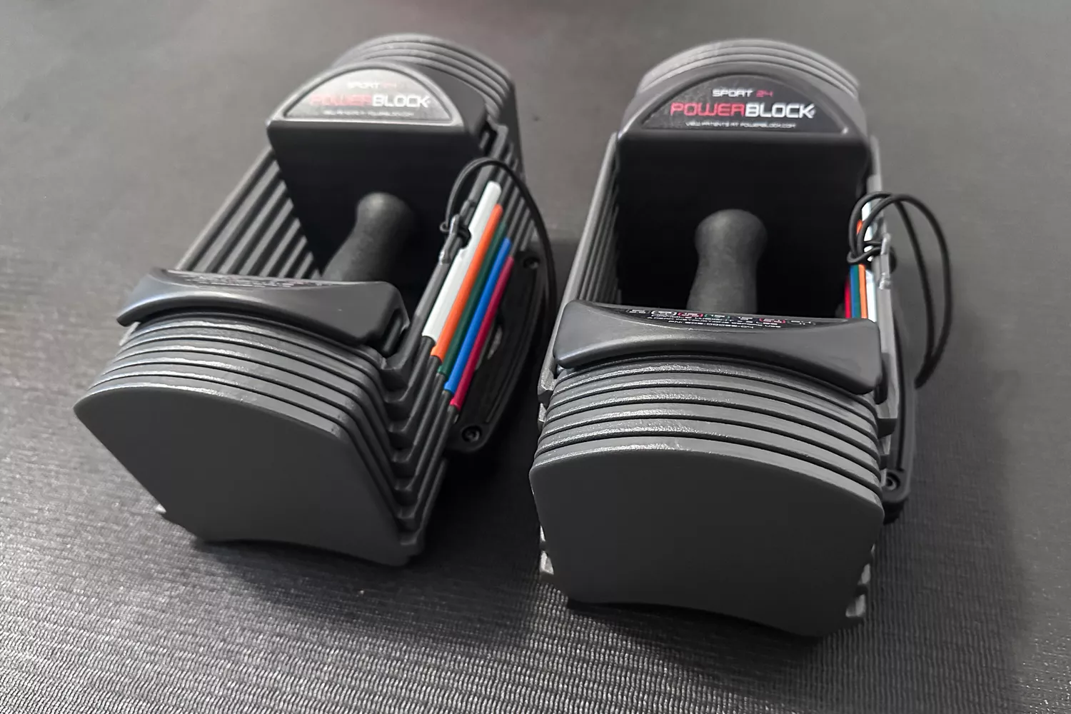 The POWERBLOCK Sport 24 Adjustable Dumbbells on an exercise mat