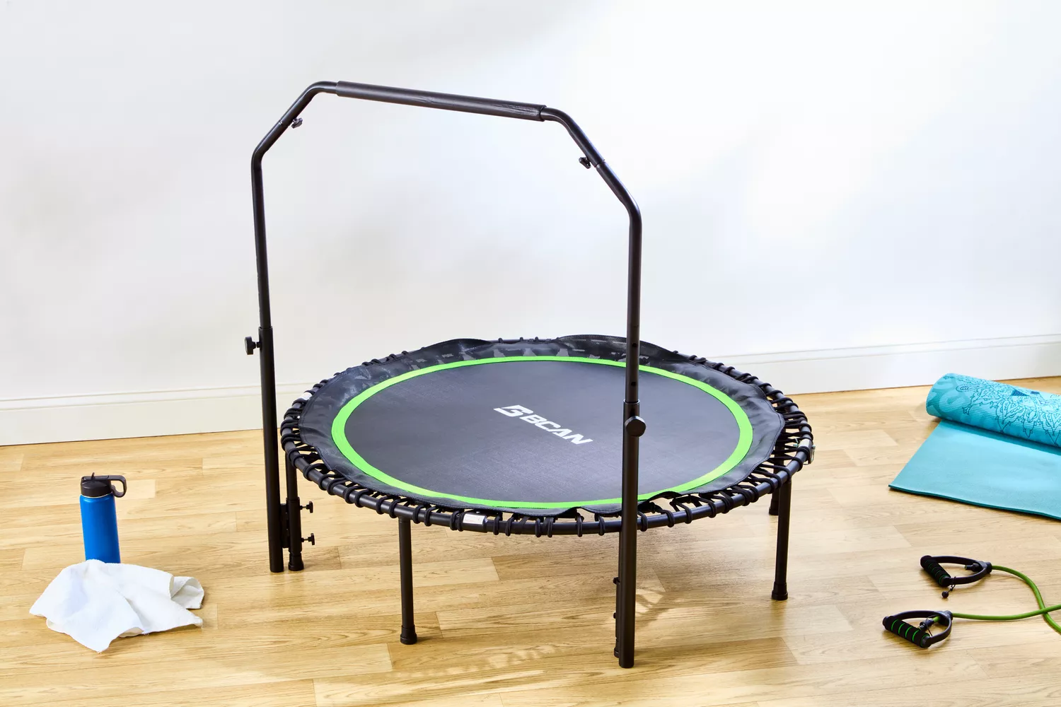 The BCAN 450/550 Lbs Foldable Mini Trampoline on a wooden floor in fitness room