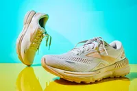 The Brooks Adrenaline GTS 23 sneakers on a shiny yellow surface