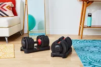 FitRx SmartBells Set Quick Select Adjustable Dumbbells on stands in fitness space setting