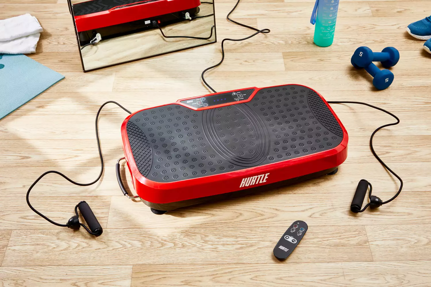 The Hurtle Fitness Vibration Platform Machine on the floor near accessories