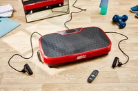 The Hurtle Fitness Vibration Platform Machine on the floor near accessories