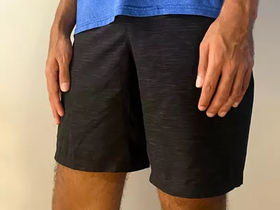 Man in a blue t-shirt wearing black lululemon Pace Breaker Linerless Shorts