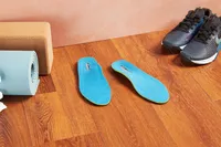 Redi-Thotics Flex Orthotic Insoles displayed on a wood floor