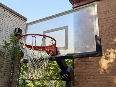 Spalding Momentous EZ Assembly Acrylic Portable Basketball Hoop outdoors in front of brick building 