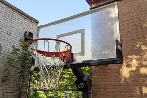 Spalding Momentous EZ Assembly Acrylic Portable Basketball Hoop outdoors in front of brick building 