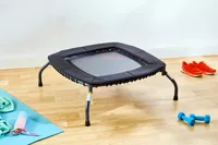 The Sunny Health & Fitness 36 Inch Indoor & Outdoor Exercise Trampoline in a room with fitness items