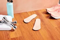Vionic Slimfit Orthotic Insoles displayed on a wood floor