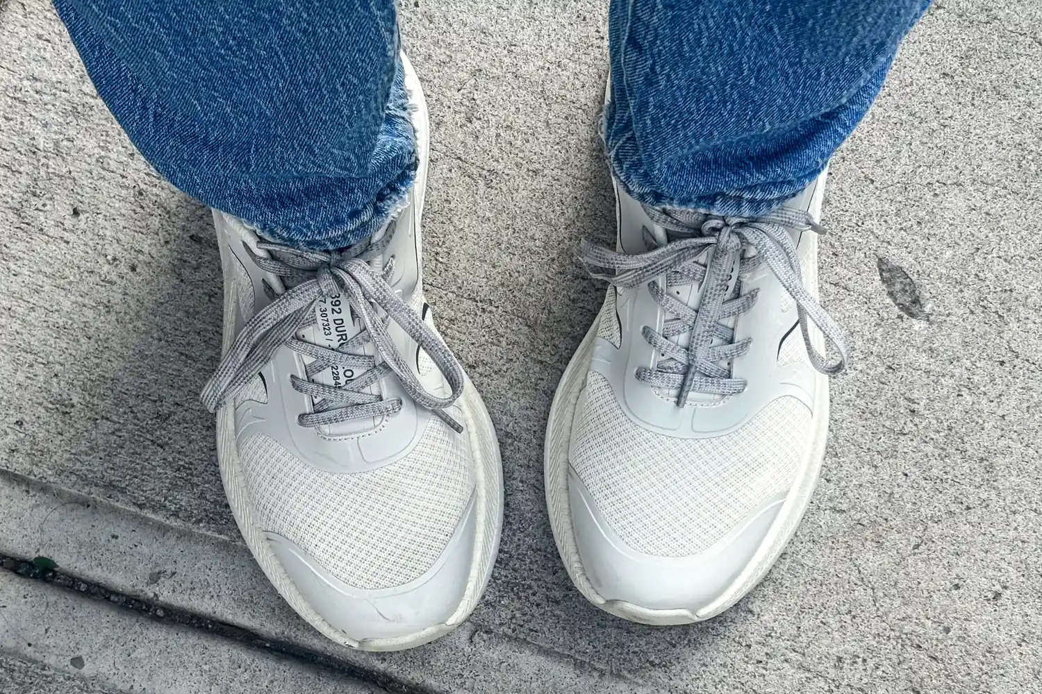 A person wearing Propét DuroCloud 392 Women's Sneaker and jeans standing on concrete