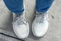 A person wearing Propét DuroCloud 392 Women's Sneaker and jeans standing on concrete