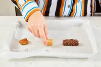 A hand reaches to touch one of three food samples labeled A B and C on a tray