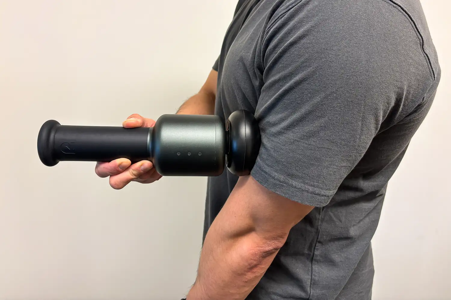 A person uses the Rally Massage Gun on their arm