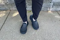 A person wearing the Hoka Restore TC Recovery Shoes on a sidewalk