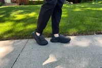 A person wearing the Hoka Restore TC Recovery Shoes on concrete