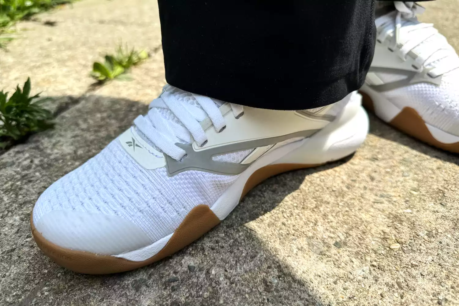 A close-up of the Reebok Nano Court worn on concrete