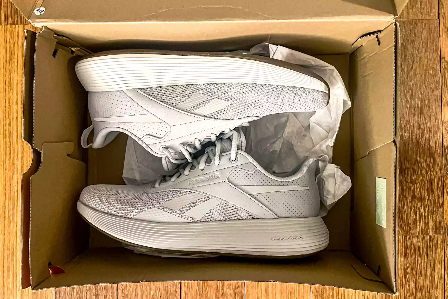 The Reebok Unisex DMX Comfort+ Walking Shoes in a shoebox