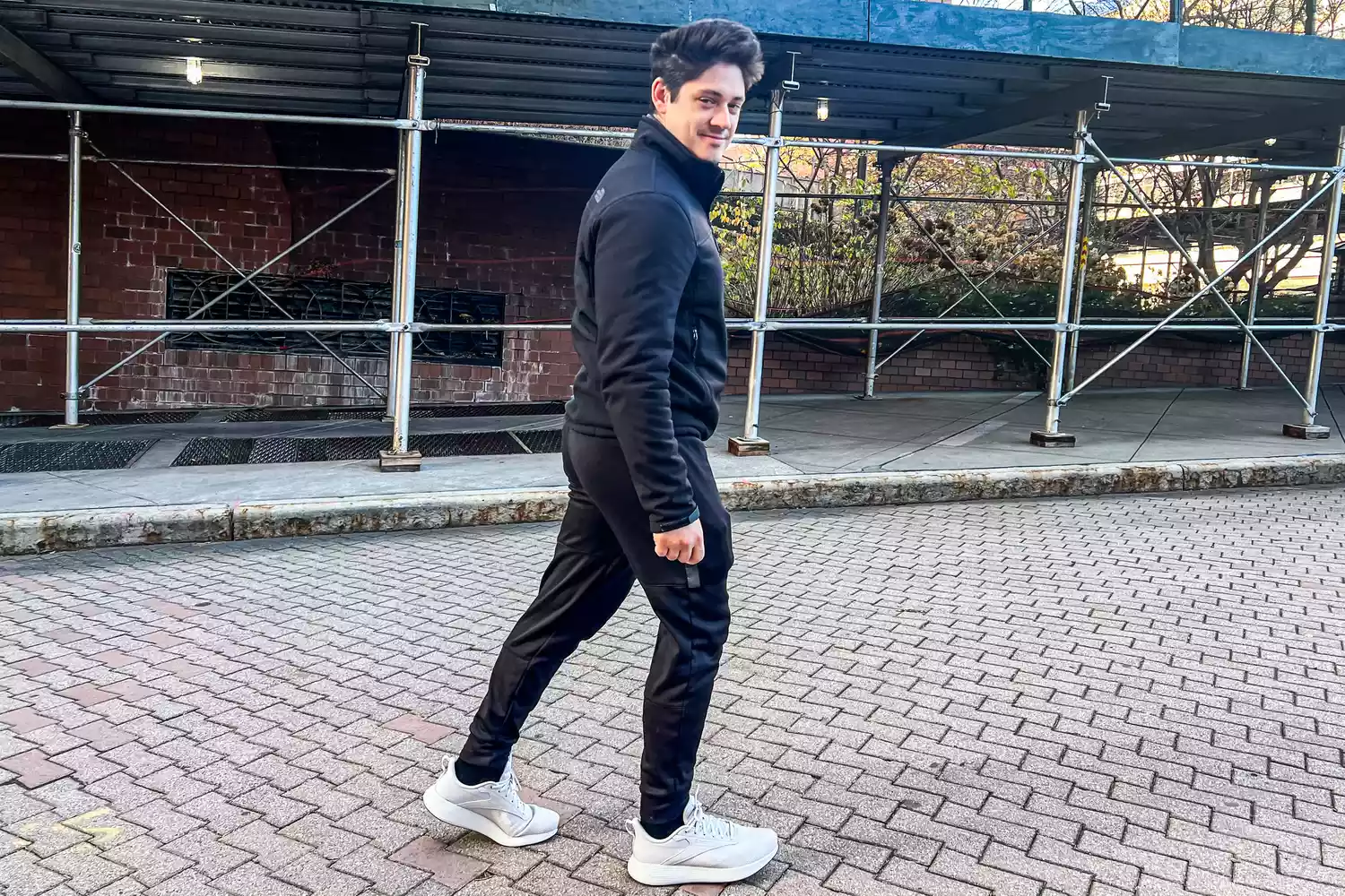 A person walks outside while wearing the Reebok Unisex DMX Comfort+ Walking Shoes