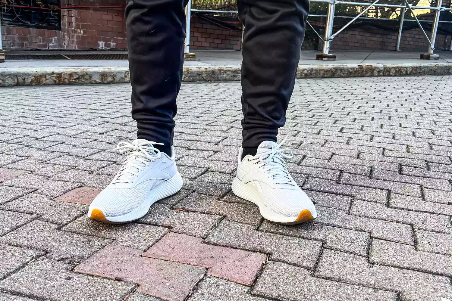 A person wears the Reebok Unisex DMX Comfort+ Walking Shoes while standing outside