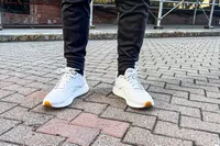 A person wears the Reebok Unisex DMX Comfort+ Walking Shoes while standing outside