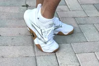 A person wears the Reebok Women's Nano Court Shoes on bricks