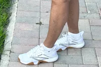 A person walks outside while wearing the Reebok Women's Nano Court Shoes