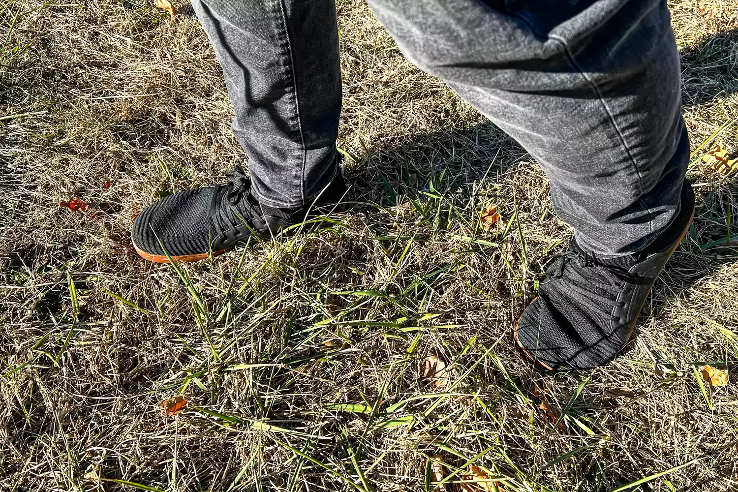 A person walks in grass while wearing the Relxfeet Men's Minimalist Barefoot Shoes