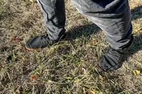 A person walks in grass while wearing the Relxfeet Men's Minimalist Barefoot Shoes