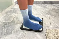 A person stands on the Renpho R-MSB02 Elis Chroma Aspire Smart Scale on a tile floor