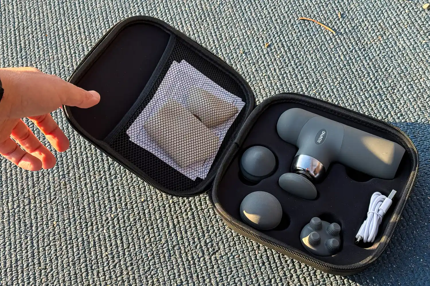 A person opens the top of the Renpho Mini Thermal Massage Gun storage case