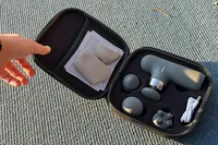 A person opens the top of the Renpho Mini Thermal Massage Gun storage case